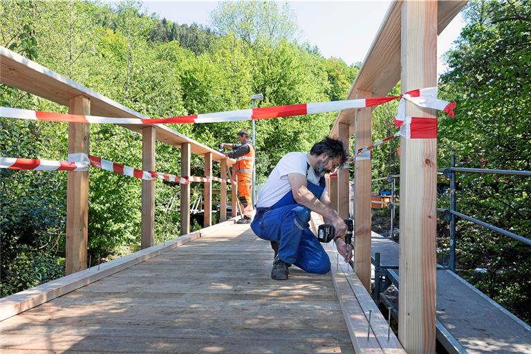 Swen Blank und Jürgen Löchner (vorne) kümmern sich um die Befestigung der Dielen und den Aufbau des Geländers der Brücke. Foto: J. Fiedler