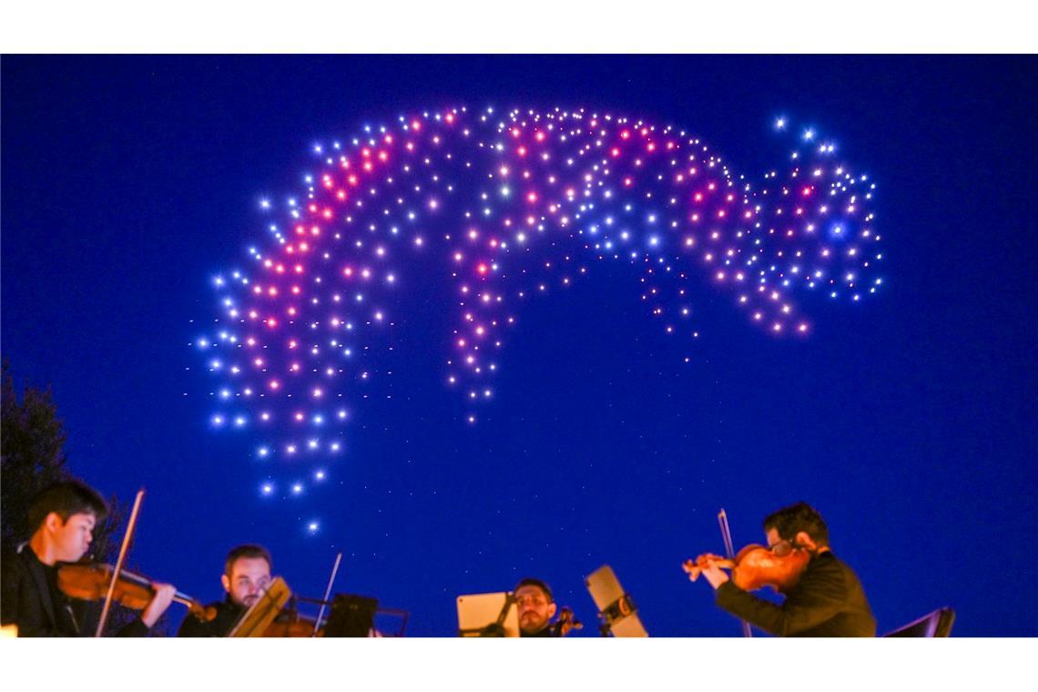 Sychronisierte Drohnen zeigen bei einer DroneArt Show Lichtbilder am Himmel über den Gärten der Welt in Berlin.