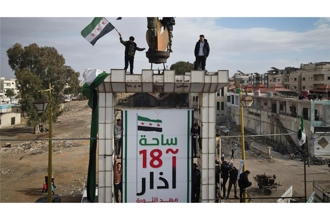 Bilder des Tages Syrer schwenken nach dem Freitagsgebet während einer Demonstration in Daraa Fahnen, um den Sturz der Regierung von Assad zu feiern.