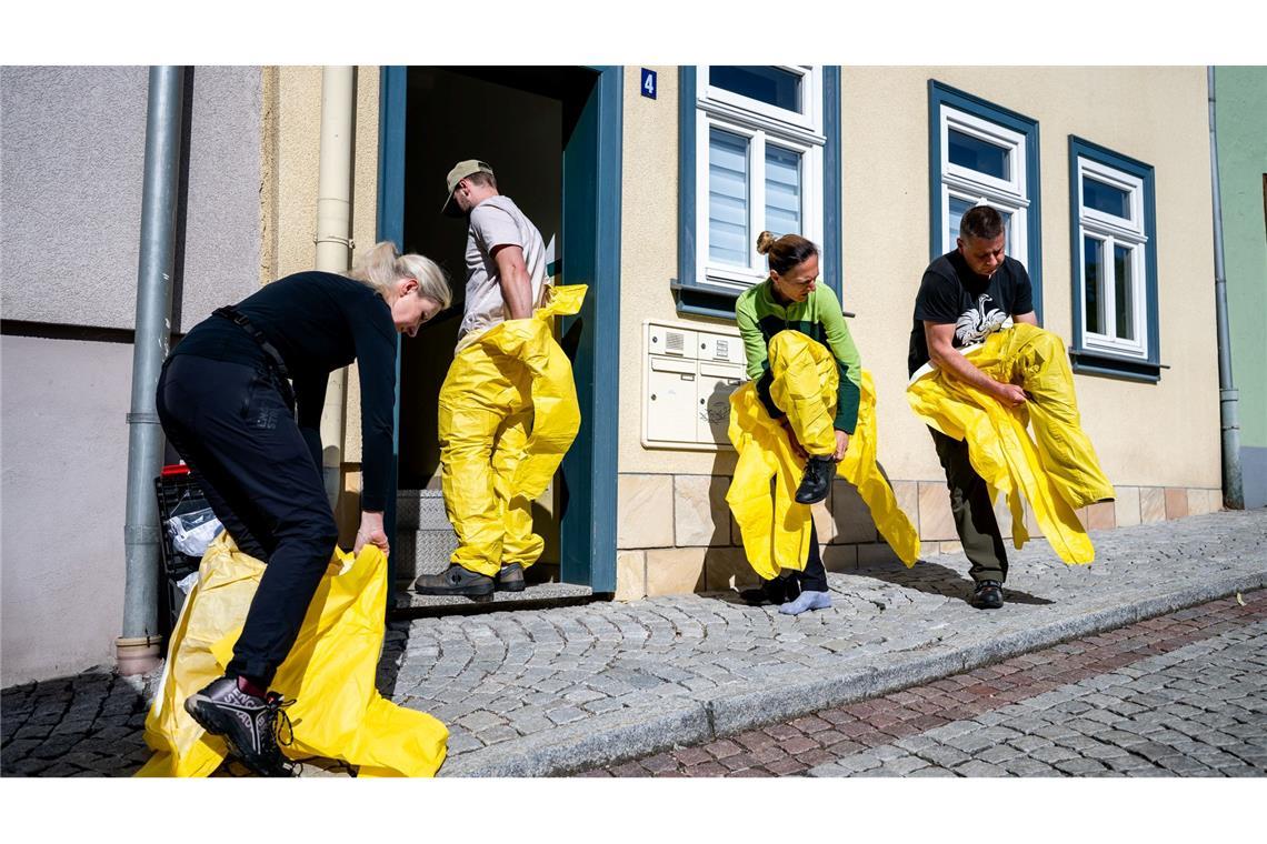 Tatortreiniger arbeiten in Ganzkörper-Schutzanzügen, mit Atemschutzmasken und Spezialhandschuhen, um sich vor Infektionen durch Krankheitserreger zu schützen.