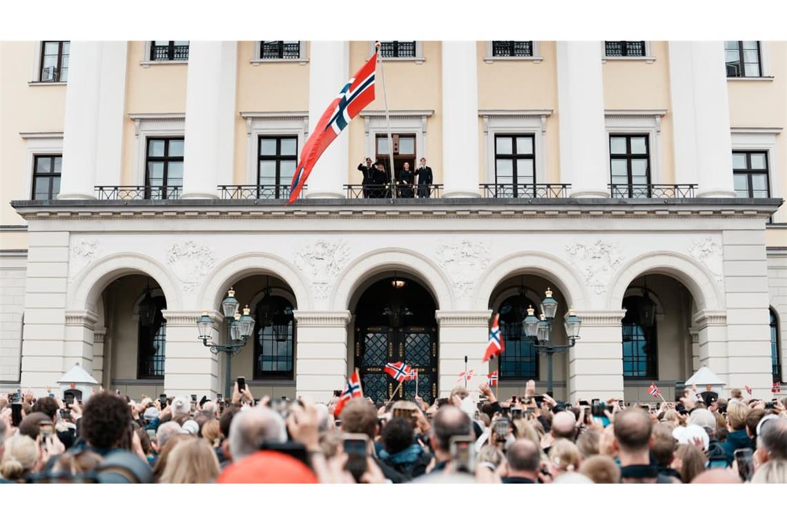 Tausende Norwegerinnen und Norweger versammeln sich vor dem Königlichen Schloss in Oslo, um der Königsfamilie nach der Beisetzung noch einmal nahe zu sein. Viele schwenken norwegische Flaggen und halten ihre Handys in die Höhe, als Haakon, Mette-Marit, Sonja, Ingrid Alexandra und Sverre Magnus auf dem Balkon erscheinen.