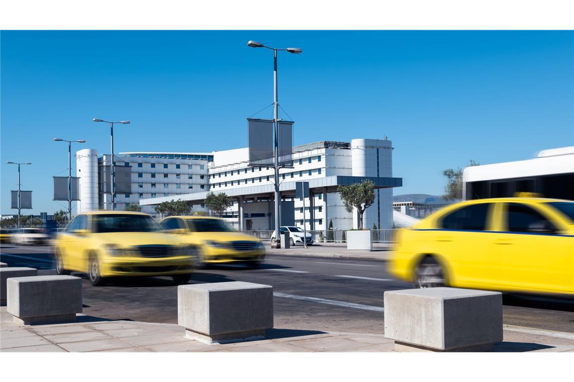 „Danke, dass Du so blöd bist!“ Taxis fahren auf der Straße am Flughafen Athen.