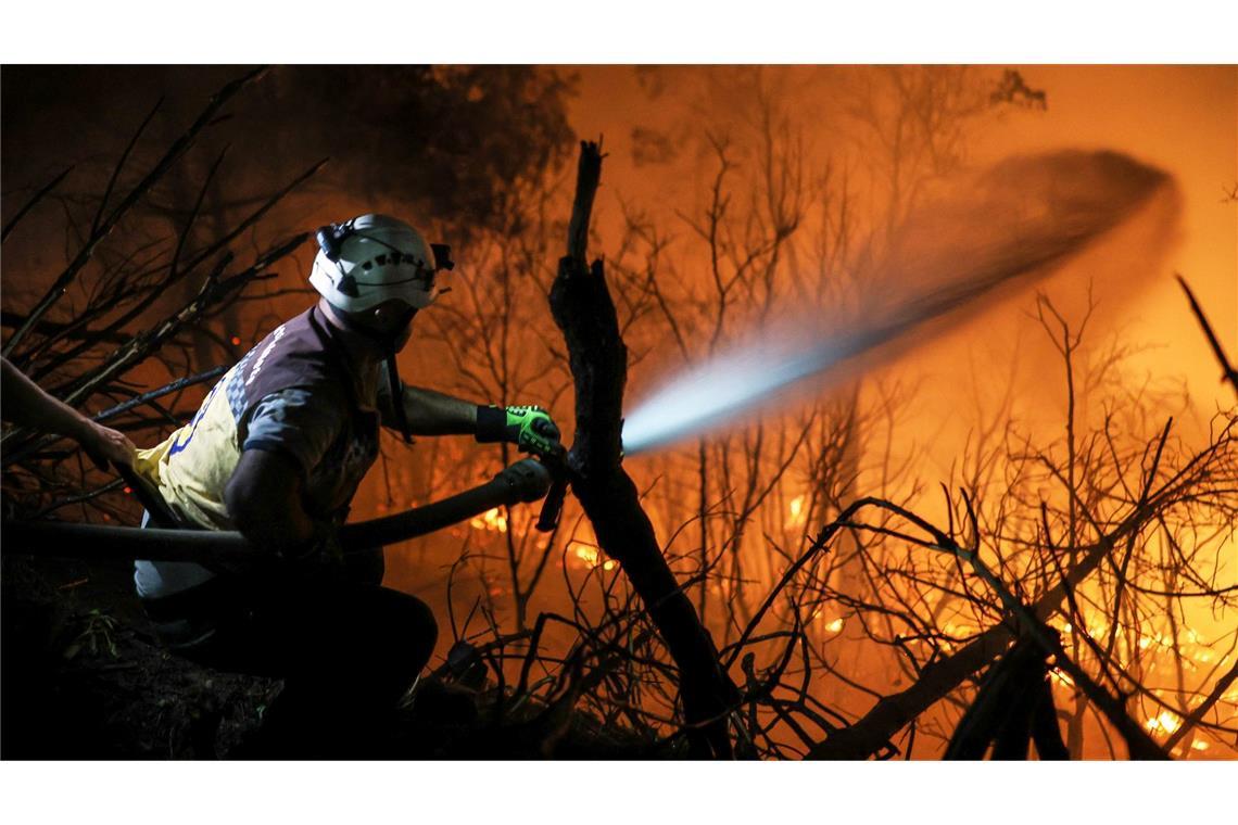 Bilder des Tages Teams des syrischen Zivilschutzes und Freiwillige bekämpfen am frühen Morgen des 12. Juli den zehnten Tag in Folge die Flammen eines Waldbrandes in der Nähe der Stadt Kasab in der syrischen Provinz Latakia.