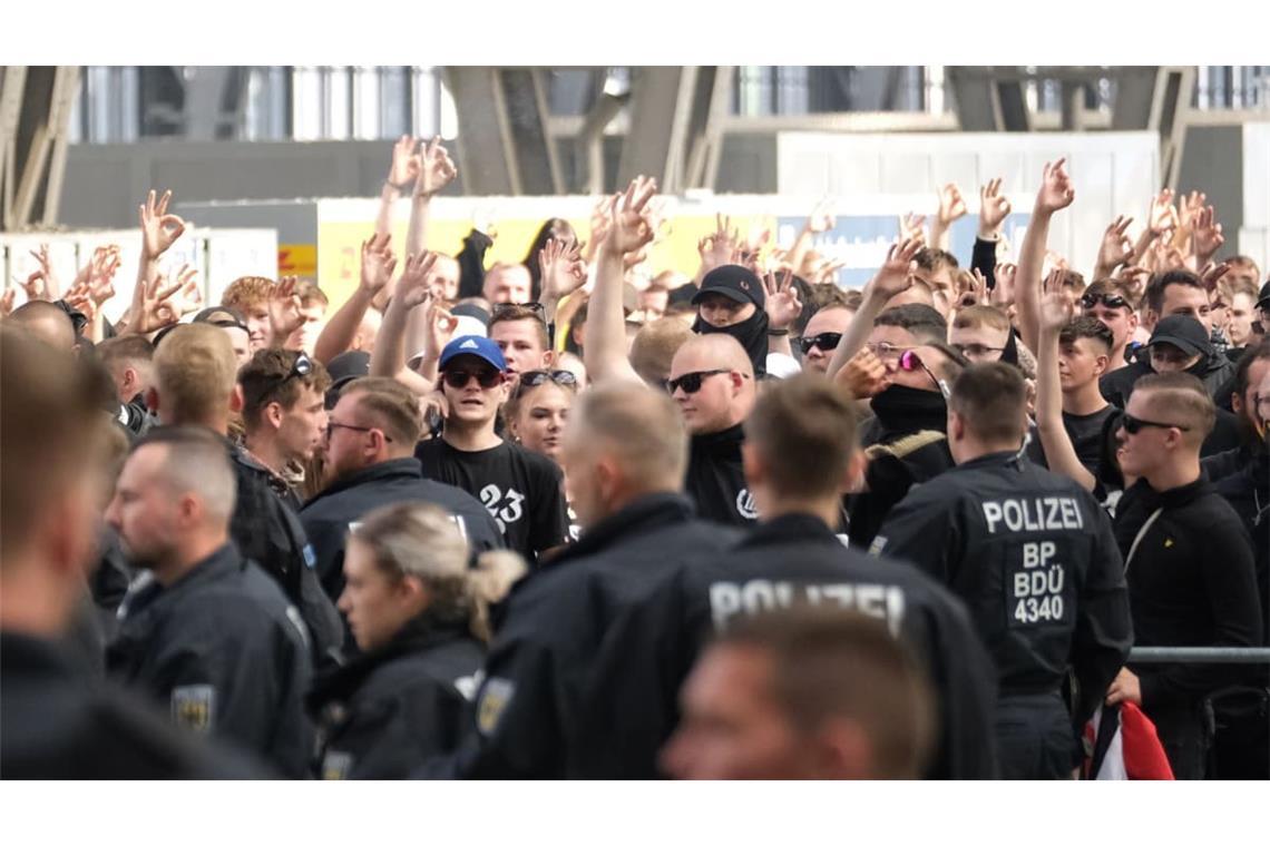 Teilnehmer einer rechtsextremen Versammlung im Hauptbahnhof zeigen das neonazistische Symbol von „White power“(dt. „weiße Macht“) mit den Händen Archivbild).