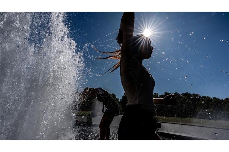 Temperaturen von annähernd 40 Grad in der Hauptstadt - diese Touristen nutzen einen Brunnen zur Abkühlung.