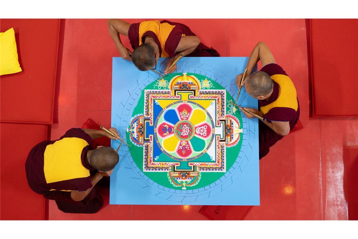 Bilder des Tages Tibetische Mönche streuen im Japanischen Palais in Dresden mit bunten Sandkörnern ein Mandala.