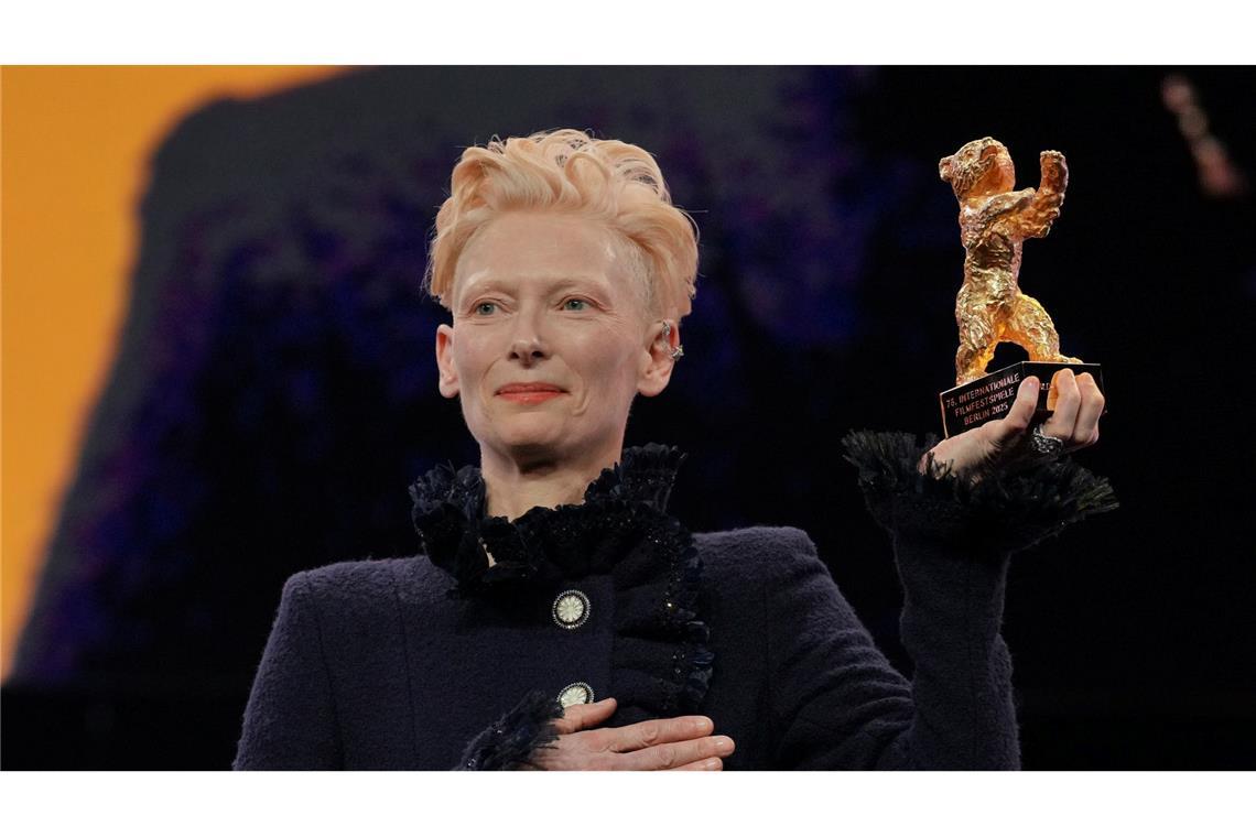 Bilder des Tages Tilda Swinton steht während der Eröffnung der Berlinale auf der Bühne und hält ihren goldenen Ehrenbär hoch.