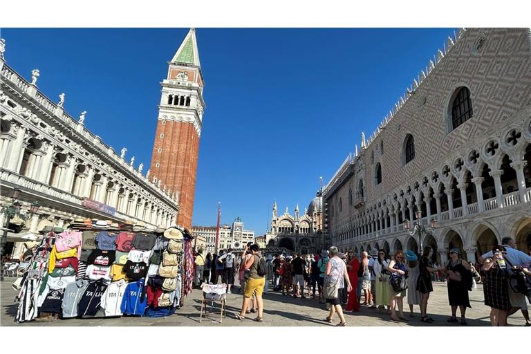 Touristen stehen auf dem Markusplatz mit Campanile (M) und Dogenpalast (r). Touristen müssen wieder Eintritt bezahlen, wenn sie nach Venedig wollen (Archivfoto).