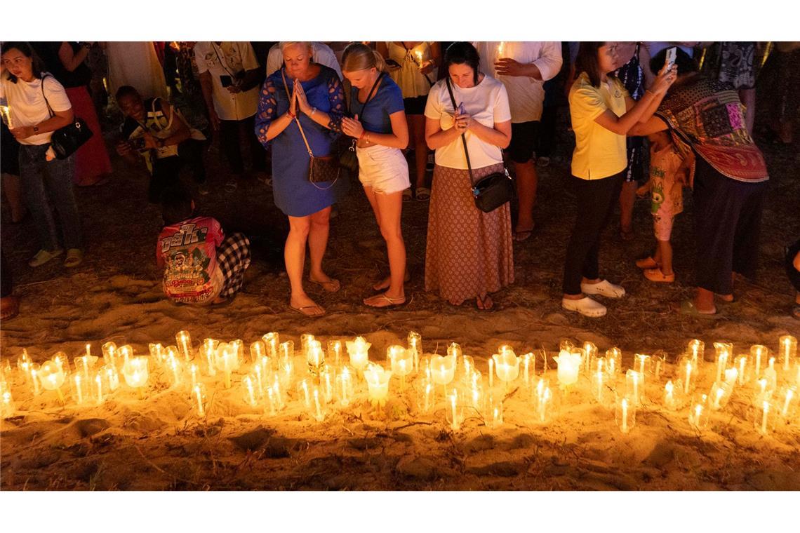 Bilder des Tages Trauer und Gedenken zum Jahrestag: Angehörige der Opfer des Tsunamis von 2004 im Indischen Ozean halten eine Mahnwache bei Kerzenlicht im Tsunami Memorial Park in Ban Nam Khem in Südthailand.