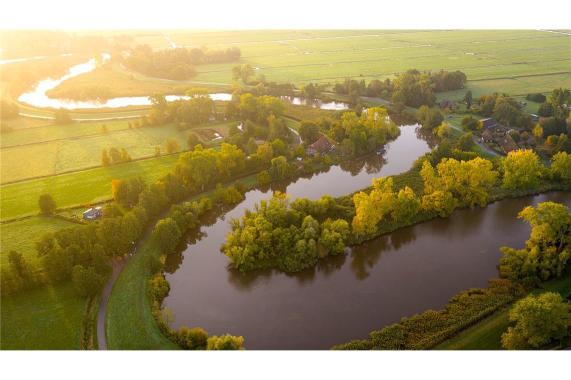 Bilder des Tages Traumlandschaft: Die Wümme fließt im Bremer Blockland vorbei an Bäumen, die bereits Herbstfarben tragen.