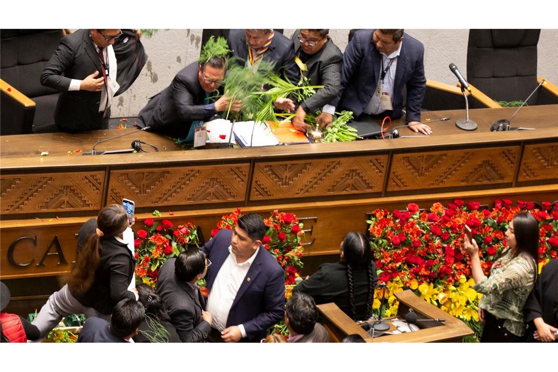 Bilder des Tages Tumult im Kongress in Bolivien. Abgeordnete, die den ehemaligen Präsidenten Evo Morales (unten) unterstützen, werfen Blumen und Wasser auf den bolivianischen Vizepräsidenten David Choquehuanca (oben, Mitte).