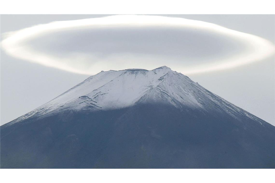 Bilder des Tages Über der schneebedeckten Spitze des Fuji ist eine ringförmige Wolke.