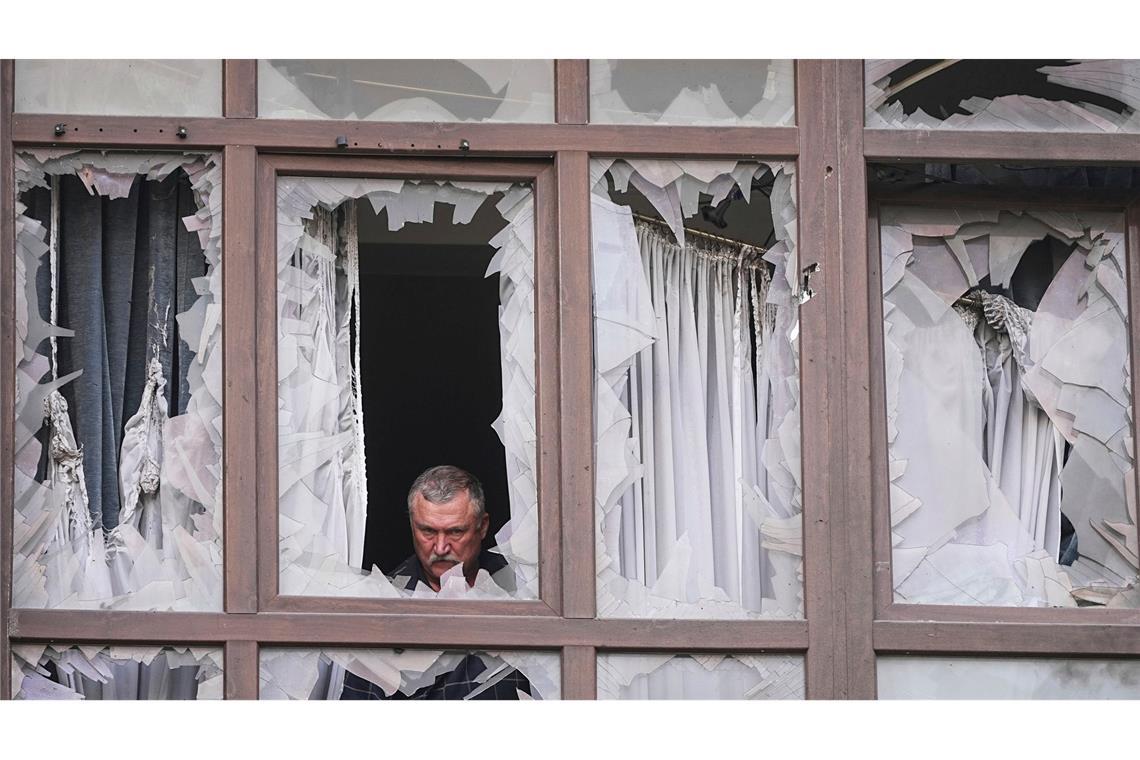 Ukraine-Krieg - Mann inspiziert zerstörtes Haus