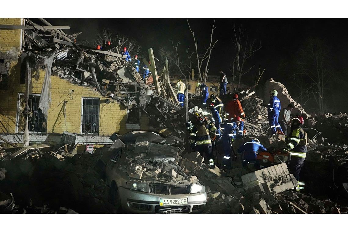 Bilder des Tages Ukrainische Helfer arbeiten in den Trümmern nach einem russischen Raketenangriff in Kiew.