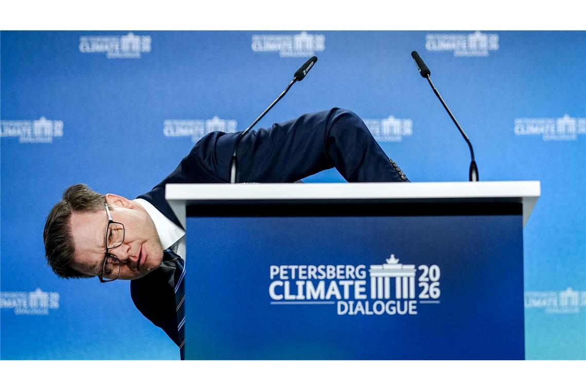 Umweltminister Carsten Schneider (SPD) beugt sich beim 17. Petersberger Klimadialog neben das Pult.