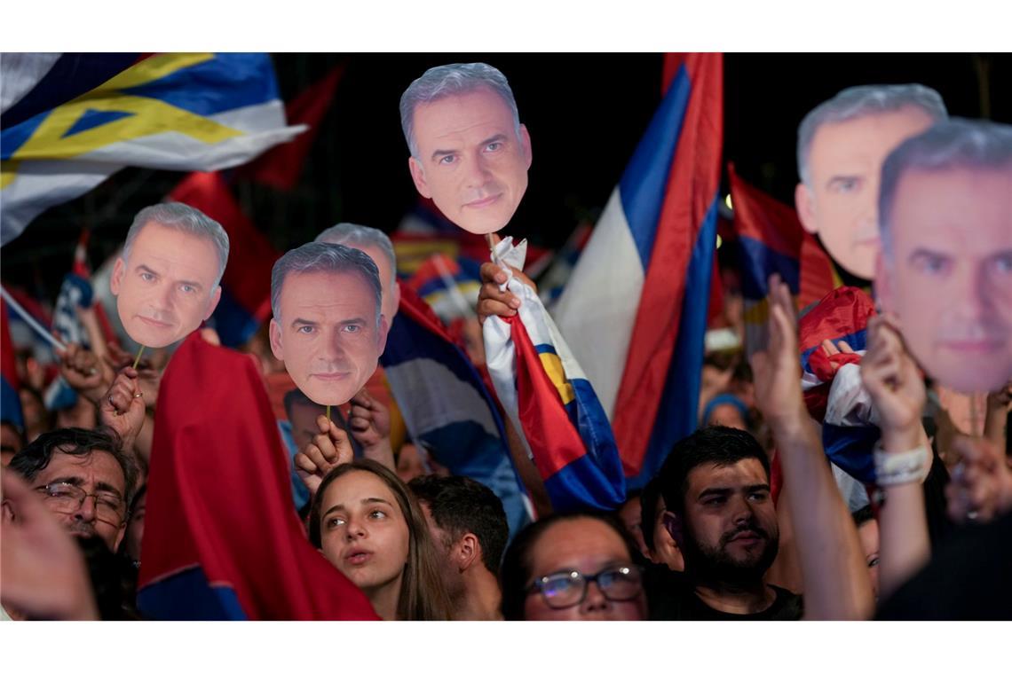Bilder des Tages Unterstützer halten Gesichtsausschnitte von Yamandu Orsi, Kandidat der Breiten Front (Frente Amplio), nach Schließung der Wahllokale bei der Präsidentschaftsstichwahl in Uruguay.