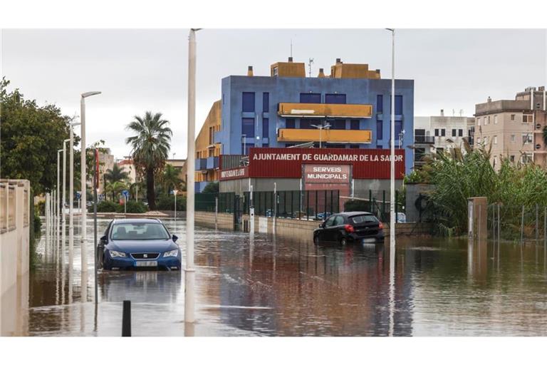 Unwetter in Spanien - Valencia: 19.10.2026, Spanien, Guardamar de la Safor: Autos stehen im Hochwasser einer überschwemmten Straße. Heftige Regenfälle haben in der Mittelmeerregion Spaniens zu schweren Überschwemmungen geführt. In den am schwersten betroffenen Gebieten im Süden der Provinz Valencia und im Norden der Provinz Alicante riefen die Behörden die Menschen auf, nach Möglichkeit in den Häusern zu bleiben.