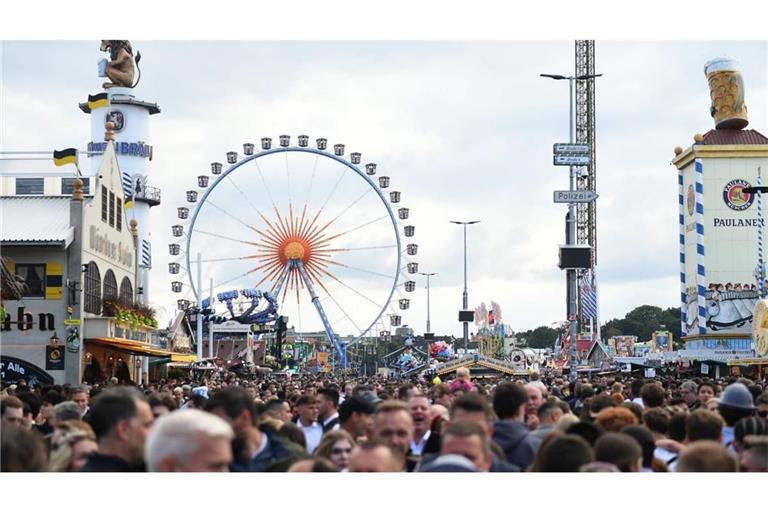 Unzählige Besucher drängen sich auf dem Oktoberfest vor dem Riesenrad.