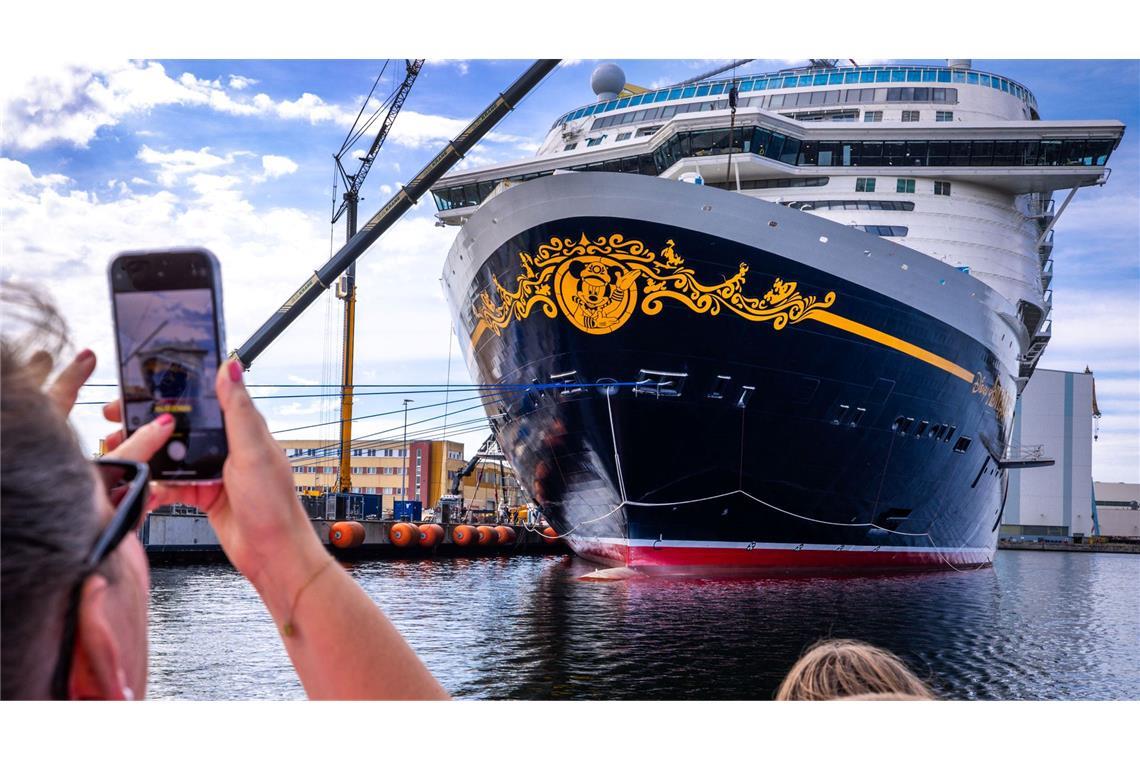 Bilder des Tages Urlauber fotografieren bei einer Hafenrundfahrt das neue Kreuzfahrtschiff „Disney Adventure“ am Ausrüstungskai der Wismarer Werft.
