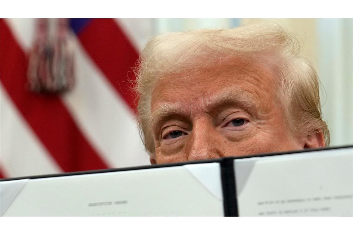 Bilder des Tages US-Präsident Donald Trump hält eine unterzeichnete Anordnung zu Kryptowährungen im Oval Office des Weißen Hauses hoch.
