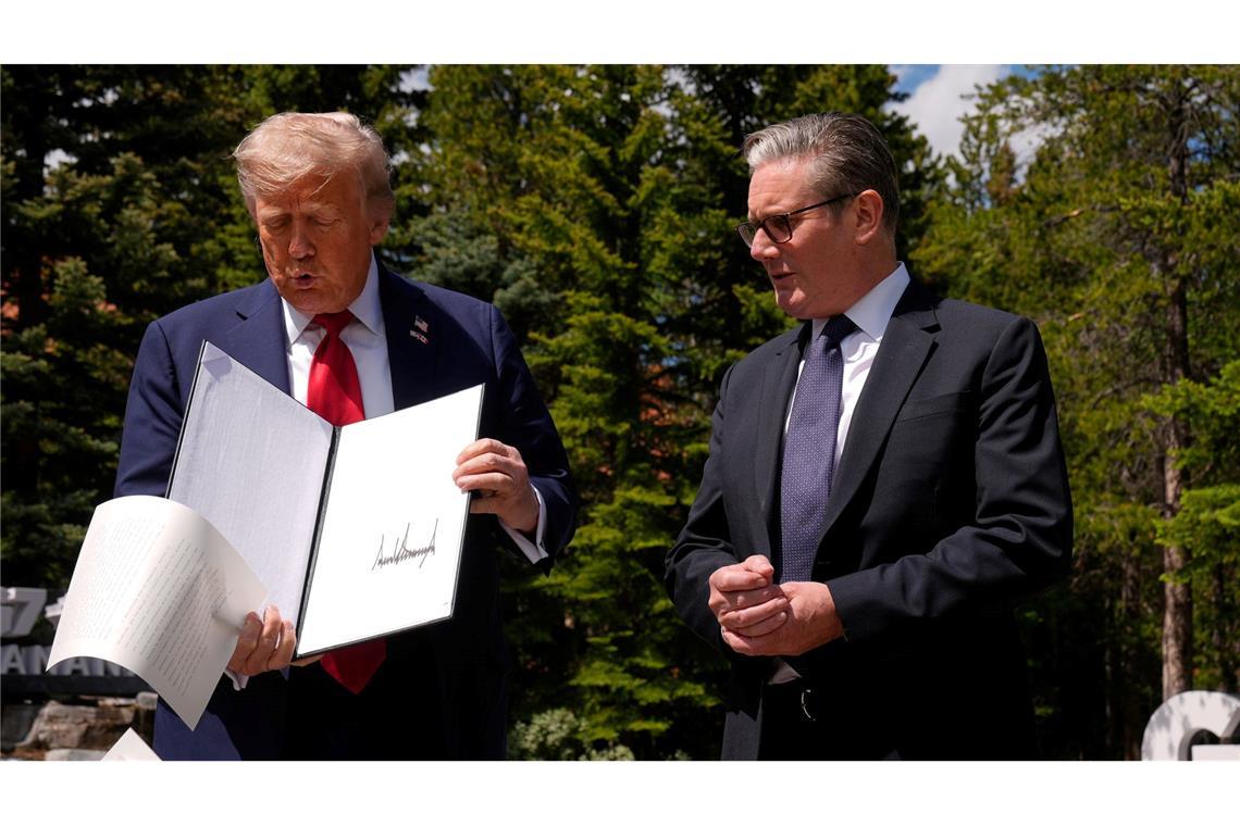 Bilder des Tages US-Präsident Donald Trump lässt Papiere fallen, als er am Rande des G7-Gipfels mit dem britischen Premierminister Keir Starmer zusammentrifft.