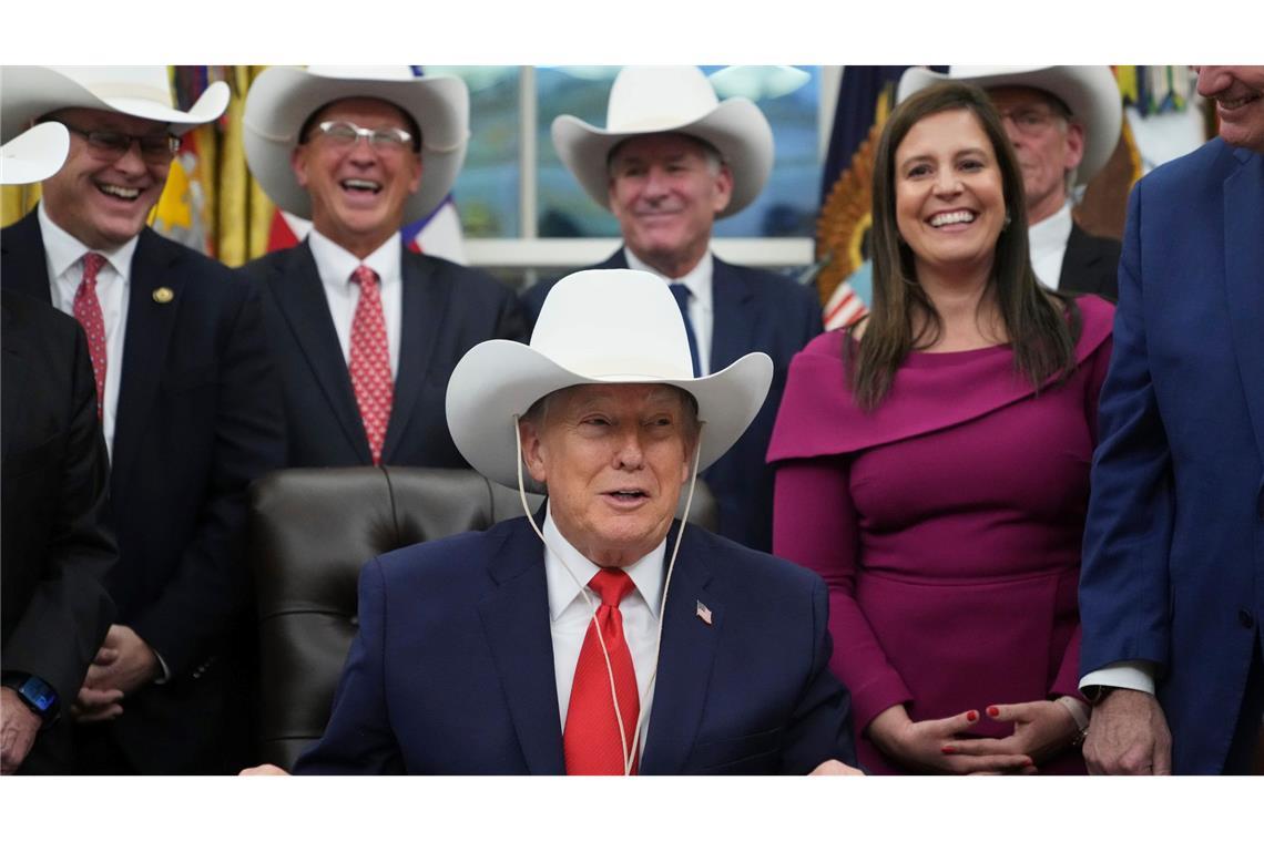 US-Präsident Donald Trump nimmt im Oval Office des Weißen Hauses in Washington an einer Zeremonie zur Unterzeichnung eines Gesetzentwurfs mit Mitgliedern des olympischen US-Eishockeyteams der Männer von 1980 teil und trägt einen Cowboyhut.