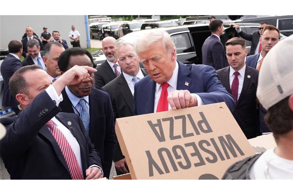 Bilder des Tages US-Präsident Donald Trump schaut sich eine Pizza an, während er sich mit Mitgliedern von Strafverfolgungsbehörden und Soldaten der Nationalgarde in Washington trifft.