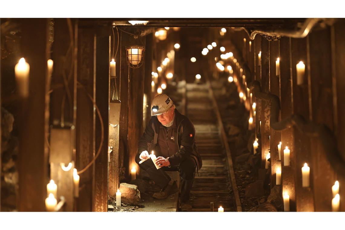 Uwe Reisner vom Förderverein Rabensteiner Stollen zündet im Stollen Kerzen an.