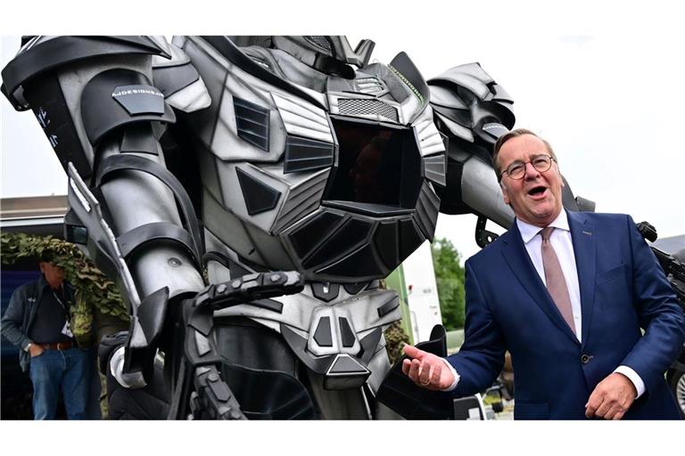 Verteidigungsminister Pistorius scherzt neben einer Transformer-Figur bei der ILA 2026 in Berlin.