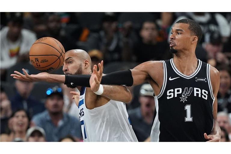 Victor Wembanyama (r) greift über Rudy Gobert (l) nach einem Rebound.