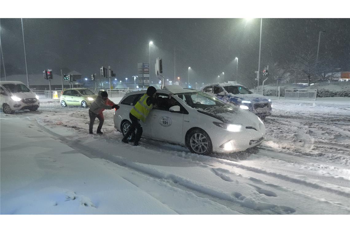 Bilder des Tages Viel Schnee in Großbritannien: Menschen helfen in Leeds dabei, im Schnee steckengebliebene Autos wegzuschieben.