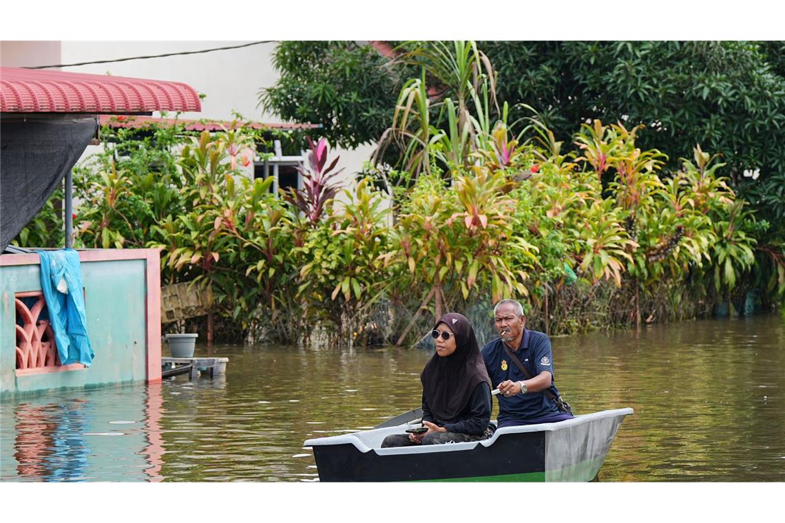 Dutzende Tote nach Extremregen in Malaysia und Thailand Viele Bürger bahnten sich in Booten einen Weg durch die Fluten.