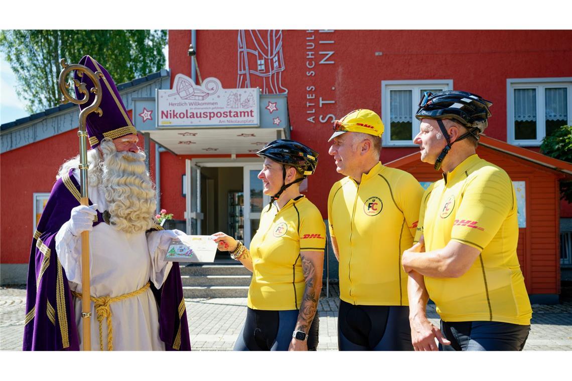 Vom Nikolaus nehmen die Radfahrer beim Start ihrer langen Tour Post für den Weihnachtsmann in Lappland entgegen.