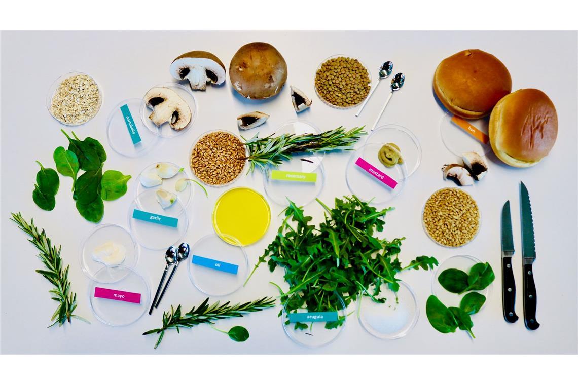 Von KI entworfene Zutaten für einen nachhaltigen und dabei leckeren Burger: unter anderem Zucht-Champignons, Rucola, Rosmarin, Körner und Gewürze.