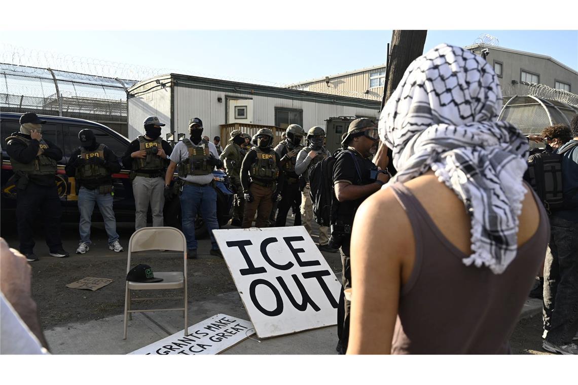 Vor Bundesbeamten der Einwanderungsbehörde ICE haben Demonstrierende ein großes Schild mit der Aufschrift "ICE out" drapiert.