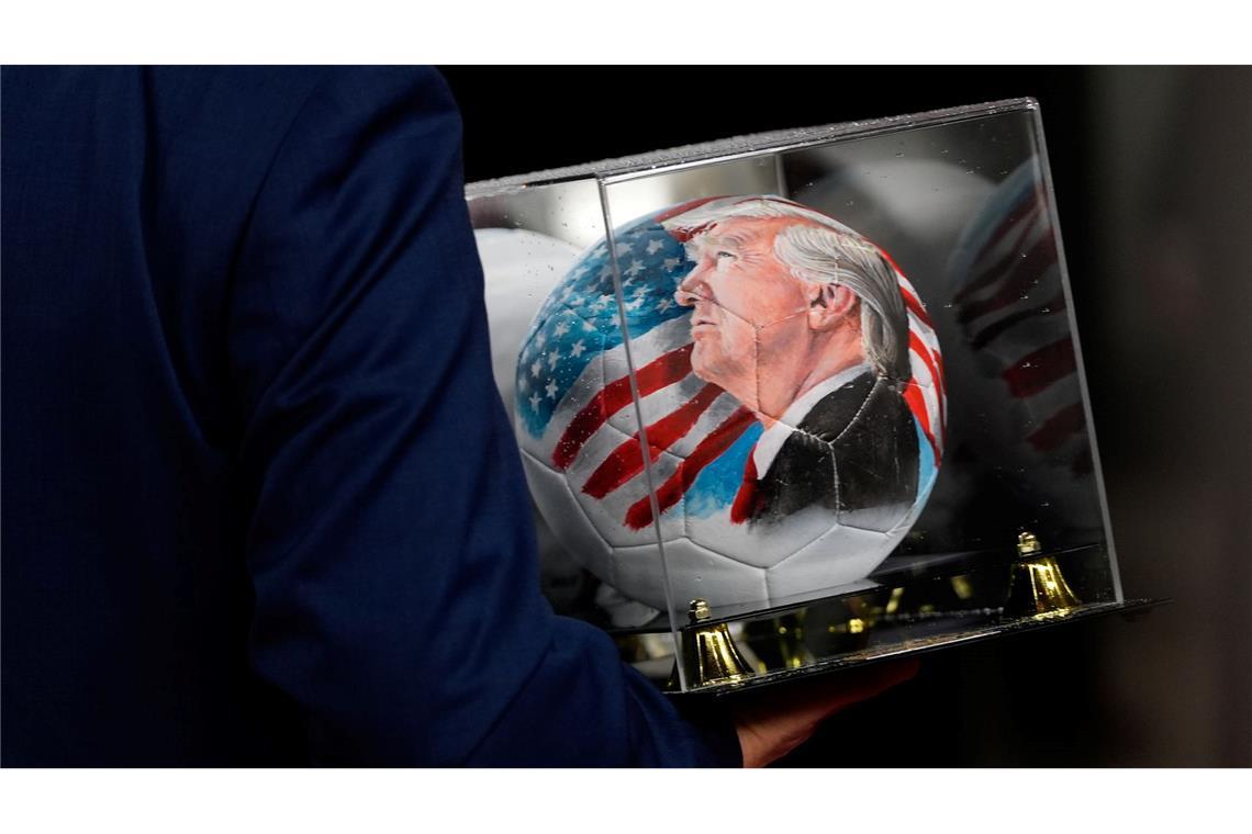 Vor der Auslosung ist auch ein Ball mit dem Gesicht von Trump zu sehen.