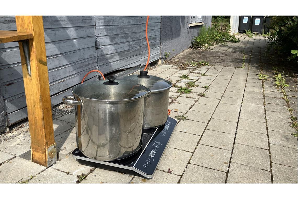 Stadt Tübingen ergreift erste Maßnahmen gegen invasive Ameisen Vor einem Haus steht ein Elektroherd mit zwei weiteren Töpfen, in denen das Wasser erhitzt wird.