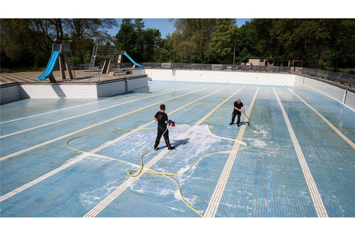 Vorbereitungen für die Freibadsaison in Hamburg: Mitarbeiter eines Reinigungsunternehmens säubern das Sprung- und Schwimmerbecken im Freibad Bondenwald.