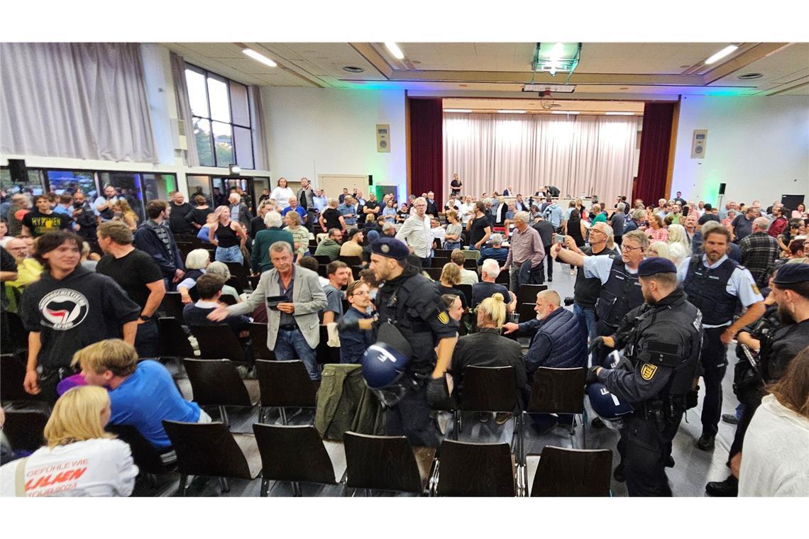 Während der Diskussion kommt es zu lautstarken Zwischenrufen, die Polizei schreitet ein.