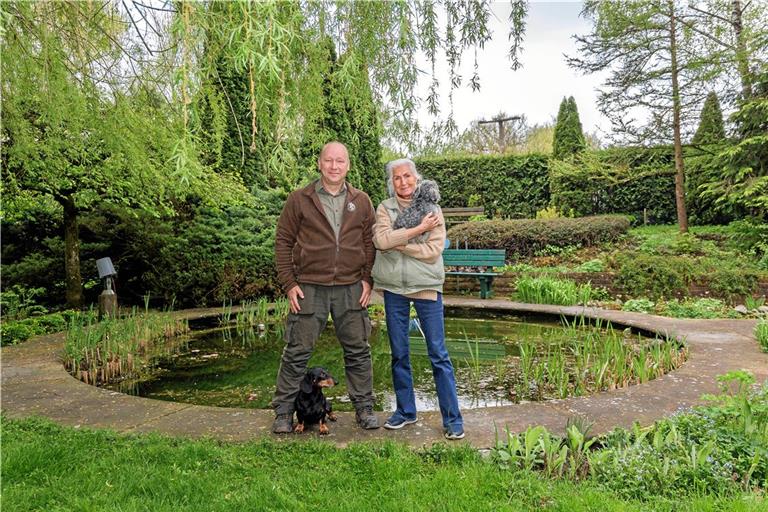 Waschbären haben im Teich von Rosemarie Güllich (rechts) sämtliche Amphibien abgeräumt und im Garten Tieren wie Igeln zugesetzt. Stadtjäger Thomas Noack hat nun eine Falle aufgestellt und hofft, dass sich die Wasserfauna später wieder erholen kann. Auf seinen Einsätzen begleitet ihn sein Dackel Cesar, der sich mit Güllichs Bolli, einem Bolonka-Zwetna-Rüden, gut versteht. Fotos: Stefan Bossow