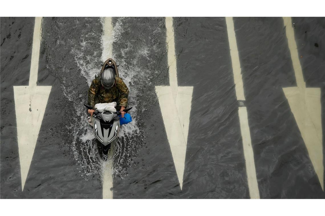 Bilder des Tages Wasserstraße: Ein Motorradfahrer fährt auf einer überfluteten Straße, nachdem Tropensturm Wipha über Manila auf den Philippinen gezogen ist.