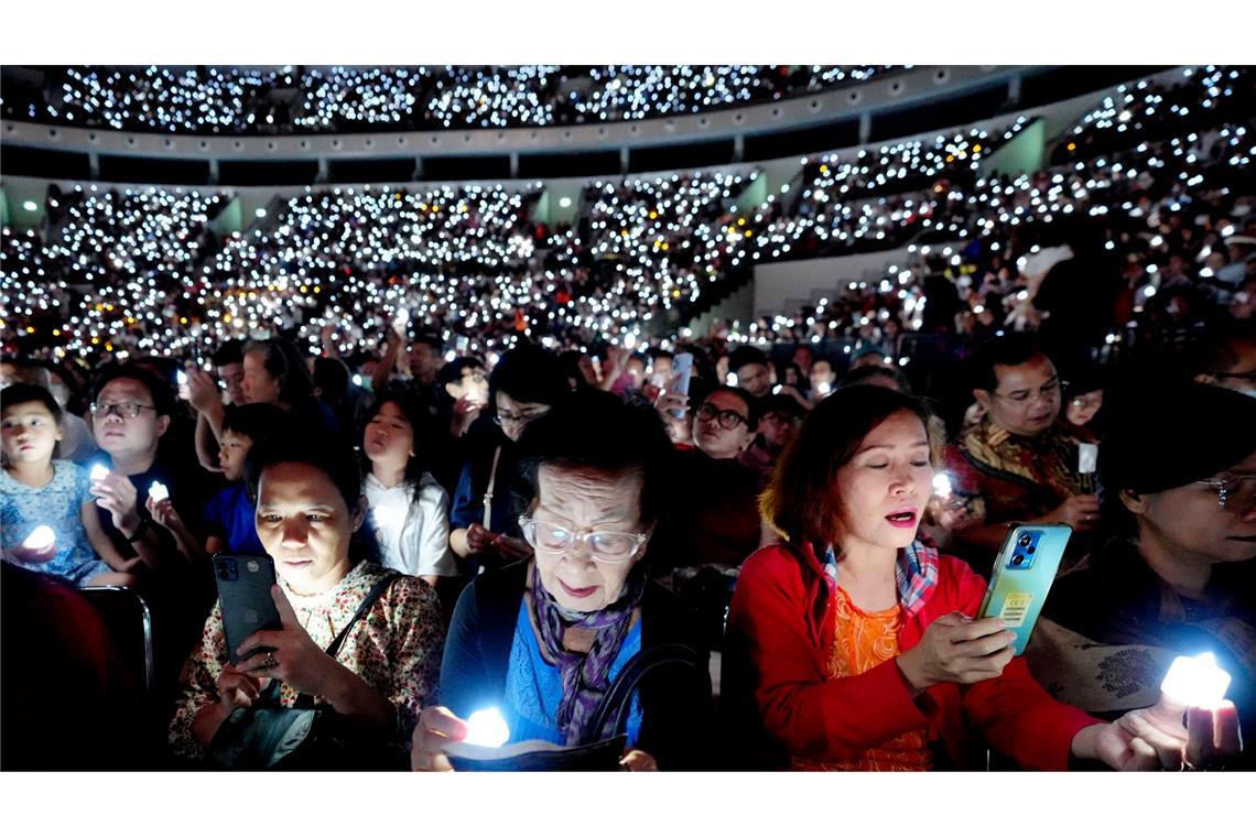 Bilder des Tages Weihnachten in Indonesien: Menschen halten elektrische Kerzen, während sie an einem Gottesdienst zu Heiligabend in Jakarta teilnehmen und singen.
