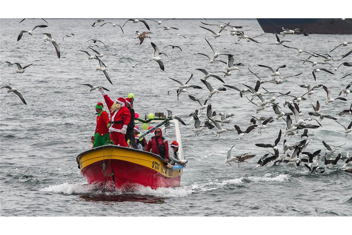Bilder des Tages Weihnachtsmann auf hoher See: Fischer von Valparaiso feiern mit Kindern in der Hafenbucht