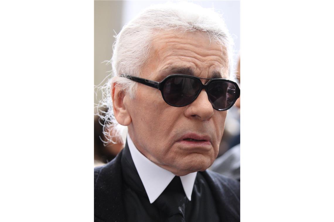 Weißer Haarschopf und schwarze Sonnenbrille waren Lagersfelds  Markenzeichen. „Die schwarzen Beinglieder assoziierten wir zum Beispiel mit den Handschuhen, die er immer trug, und die riesigen schwarzen Augen mit seiner Brille“, erklärte Danilo Harms, der zu den Namensgebern zählt.
