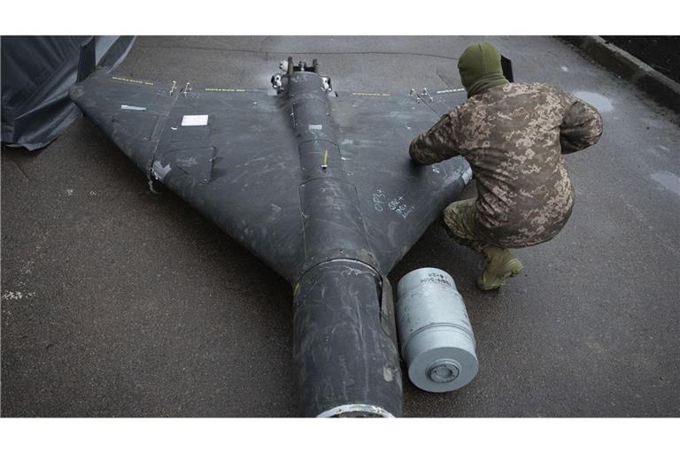 Weltweit führende Experten: ein ukrainischer Soldat untersucht bei Kyjiv eine abgeschossene russische Shahed-Drohne iranischer Bauart.