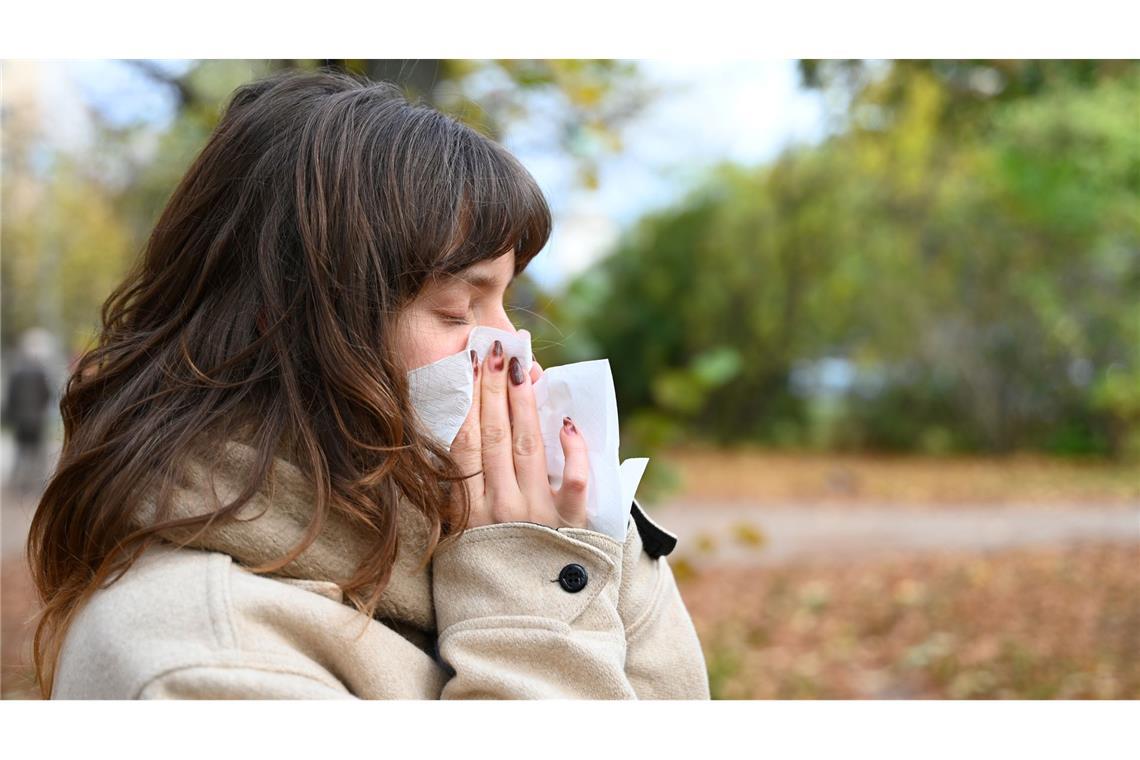 Wer niesen muss, sollte sich von anderen Personen abwenden und ein Taschentuch oder die Armbeuge vor Mund und Nase halten (Symbolbild).