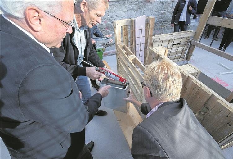 Werner Stingel, Uwe Weber und Spiegelbergs Bürgermeister Uwe Bossert (von links) sind gerade dabei, die Zeitkapsel zu verschließen. Sie findet später ihren Platz im Mauerwerk. Foto: J. Fiedler