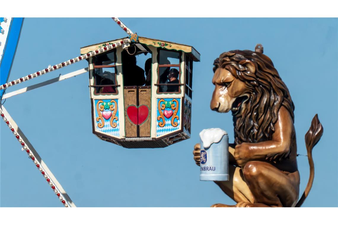 Bilder des Tages Wiesn-Besucher fahren in einem Riesenrad auf dem 190. Münchner Oktoberfest an der Kulisse einen überdimensionalen Löwen mit Bierkrugs vorbei.