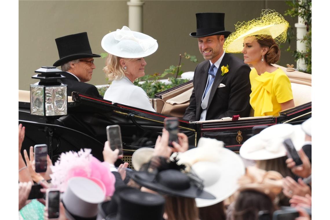William (2.v.r.), der Prinz von Wales, und Kate (r), die Prinzessin von Wales, treffen am zweiten Tag des Royal Ascot auf der Pferderennbahn von Ascot in Berkshire mit der Kutsche ein.