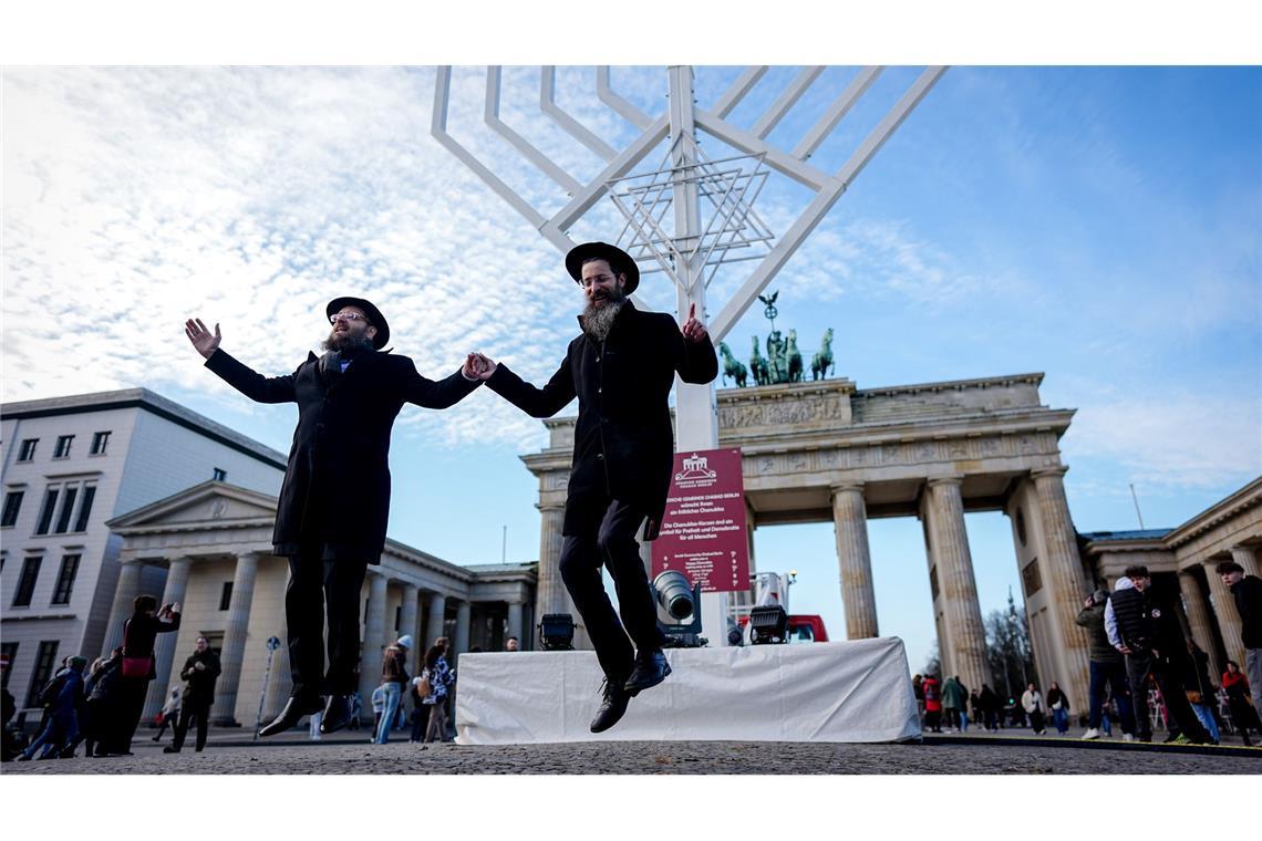 Yehuda Teichtal (l), orthodoxer Rabbiner, und Rabbi Shmuel Segal tanzen bei der Einweihung des Chanukka-Leuchters am Brandenburger Tor in Berlin.